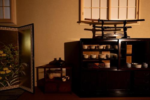 a room with a mirror and a shelf with dishes at Ryokan Suzuri 旅館 すずり in Tokyo