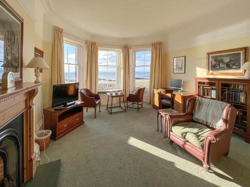 a living room with a couch and a television at Ruddon Grange in Elie