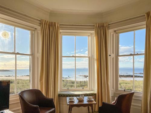 a room with windows with a view of the ocean at Ruddon Grange in Elie