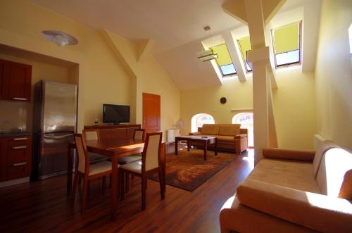 kuchnia i salon ze stołem i krzesłami w obiekcie Apartamenty Pomerius w mieście Kwidzyn