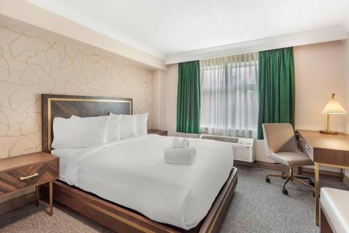 a hotel room with a large bed and a desk at Velora Hinton, an Ascend Collection Hotel in Hinton