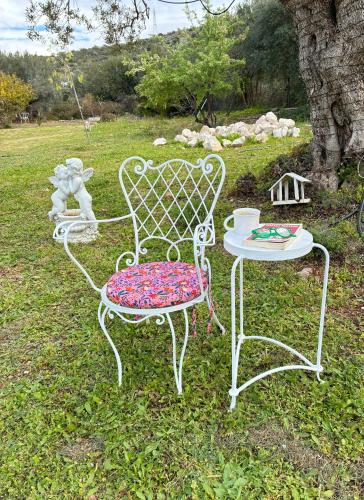 a couple of chairs and a table in the grass at Eudaimonia Wooden Suites Nafplio Kandia in Kandia