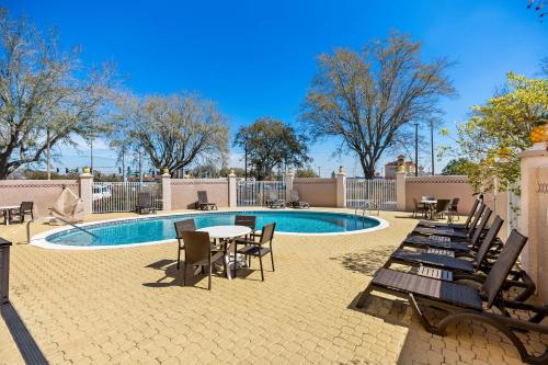 a patio with tables and chairs next to a pool at Comfort Inn & Suites Lakeland North I-4 in Lakeland