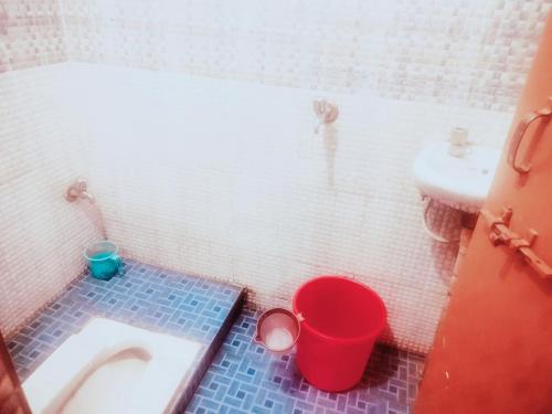 a bathroom with a toilet and a sink and buckets at Hotel shyama inn in Lucknow