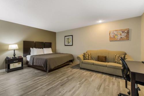 a hotel room with a bed and a couch at Econo Lodge Inn & Suites Yankton in Yankton