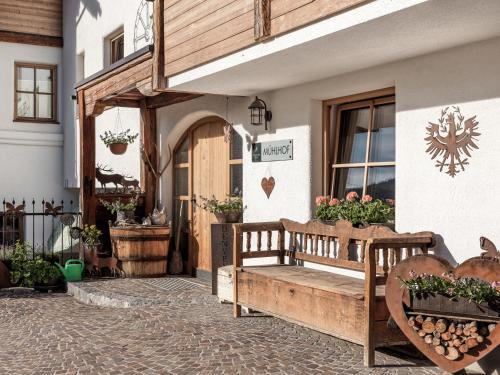 a wooden bench sitting outside of a building at MYALPS Mühlhof inklusive Sauna in Oetz