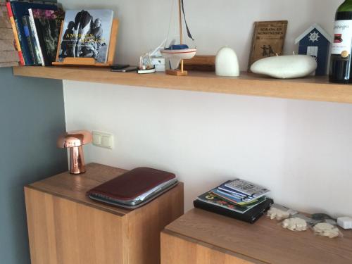 a shelf with a wallet and books on a wooden cabinet at Sonnehûs in Hindeloopen
