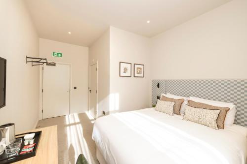 a bedroom with a large white bed in a room at Joivy Royal Mile Aparthotel in Edinburgh