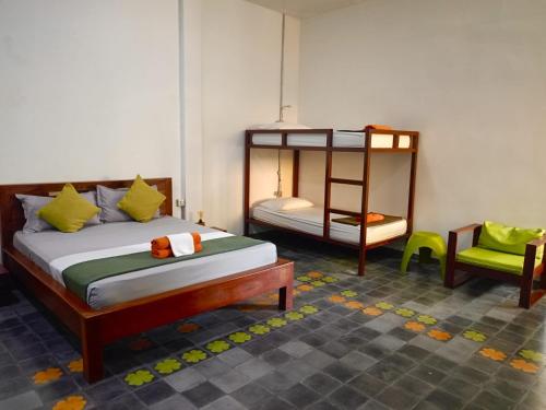 a bedroom with a bed and a bunk bed and a chair at Passport Villa in Siem Reap