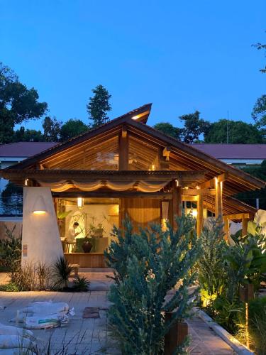 a home with a lit up porch at night at Nong Lam Ecolodge in Linh Xuân Thôn
