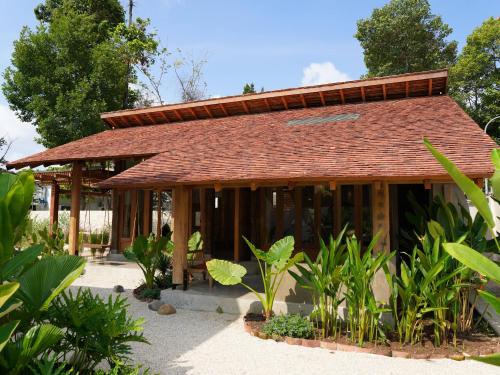 a small building with a brown roof at Nong Lam Ecolodge in Linh Xuân Thôn
