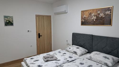 a bedroom with a bed and a picture on the wall at Sobe Magnolija, self check-in in Vinkovci