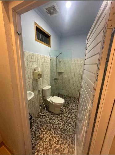a bathroom with a toilet and a sink at Cherry Homestay in Kuta Lombok
