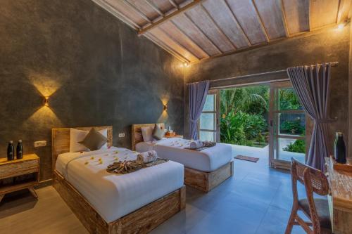 a bedroom with two beds and a large window at Menjangan Dive Lodge in Banyuwedang