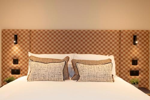 a bedroom with a white bed with two pillows at Joivy Royal Mile Aparthotel in Edinburgh