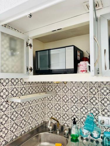a microwave sitting on a shelf above a kitchen sink at Suite Acapulco vista al mar in Acapulco