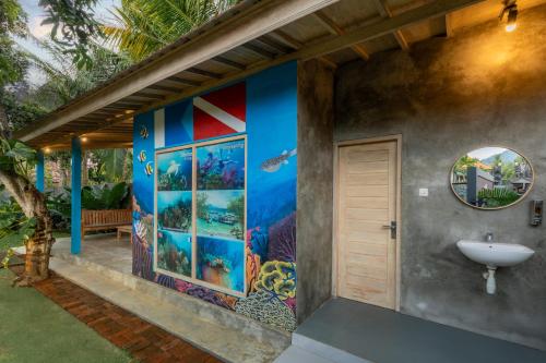a bathroom with a wall mural of an aquarium at Menjangan Dive Lodge in Banyuwedang