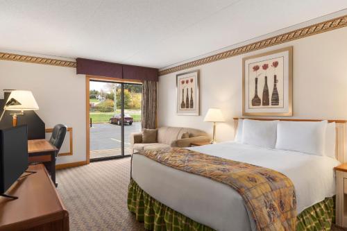 Pokój hotelowy z dużym łóżkiem i telewizorem w obiekcie Travelodge by Wyndham Owen Sound ON w mieście Owen Sound