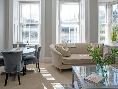 a living room with a couch and a table at Lovely Little Let in Birnam