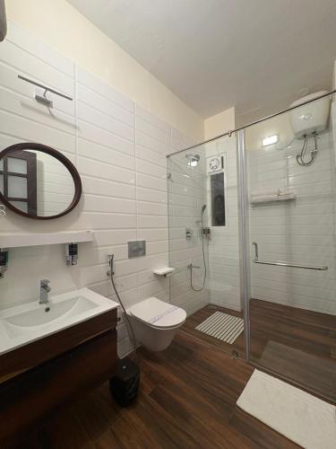 a bathroom with a shower and a toilet and a sink at Lynton Resorts in Kotagiri