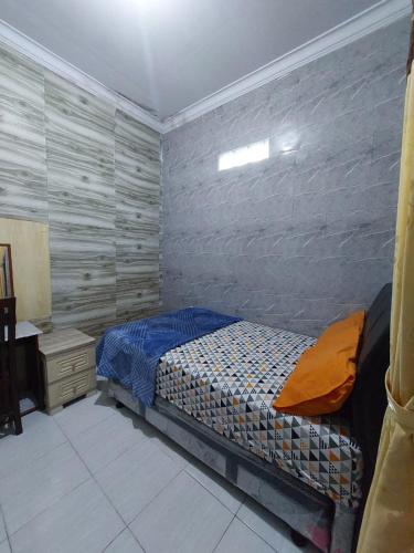 a bedroom with a bed and a table in it at Clara Guest House in Seturan