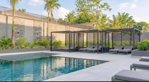 a swimming pool with lounge chairs next to a building at Urban Nook, The Bantree in Accra
