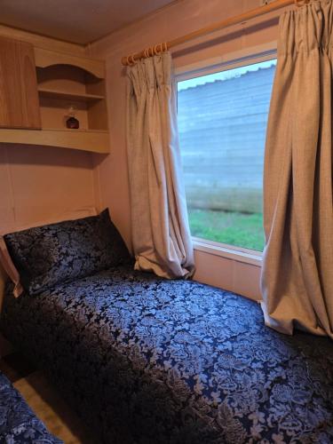 a bed in a small room with a window at Dora's 5 Berth Static with stunning views in Saint Martin