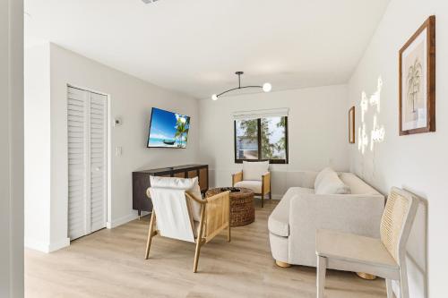 a white living room with a couch and chairs at Jefferson Avenue Suites in Miami Beach