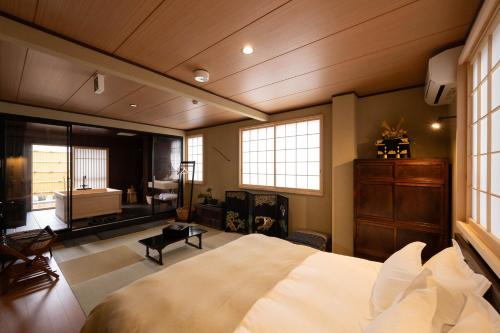 a bedroom with a large bed and a bathroom at Ryokan Suzuri 旅館 すずり in Tokyo