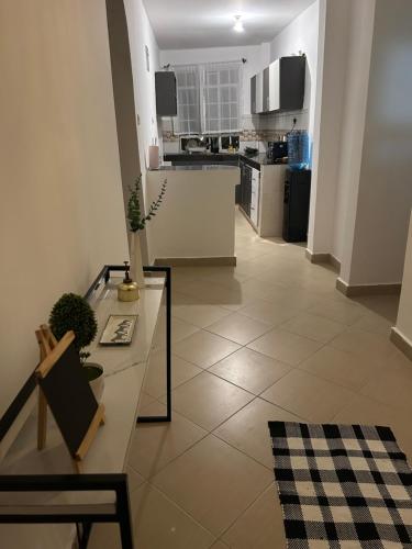 a living room with a table and a kitchen at Serene Sidai in Nairobi