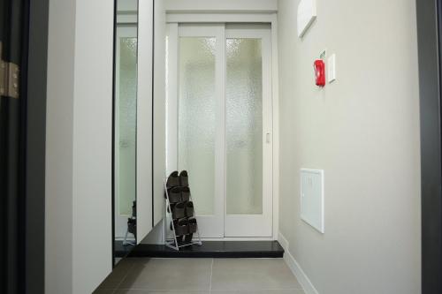 a hallway with a glass door and a chair at Eunhasu D&M Residence in Daejeon