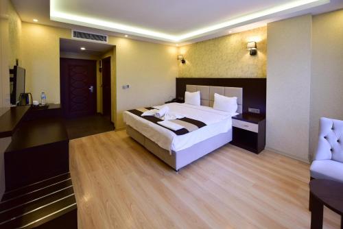 a bedroom with a large white bed in a room at Dogramaci Hotel City in Tosya