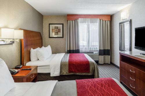 a hotel room with two beds and a television at Comfort Inn & Suites West Springfield in West Springfield