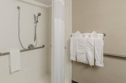 a bathroom with a shower and white towels at Comfort Inn & Suites West Springfield in West Springfield