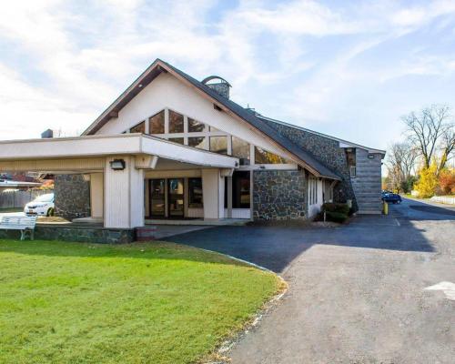 a home with a stone house with a driveway at Econo Lodge Inn & Suites Colonie Center Mall in Albany