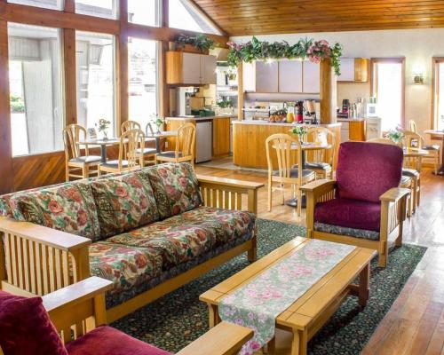 a living room with a couch and chairs and a kitchen at Econo Lodge Inn & Suites Colonie Center Mall in Albany