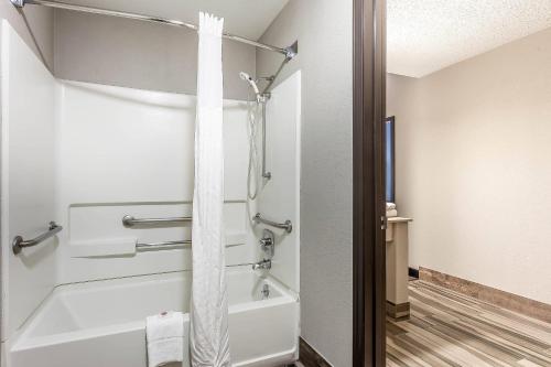 a bathroom with a bath tub with a shower curtain at Comfort Inn Cleveland Airport in Middleburg Heights