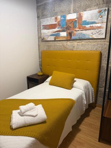a bedroom with a bed with a yellow headboard at Vida Entre Balcones in Combarro