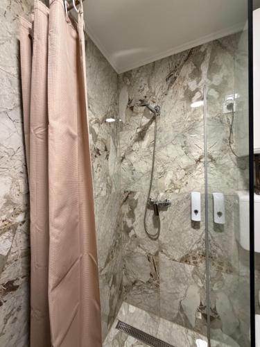 a bathroom with a shower with a shower curtain at Vlasic Apartmani HANA in Vršac