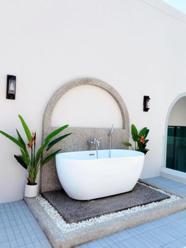 a bathroom with a white bath tub in a room at Nacha Pool Villa Cha-am in Cha Am