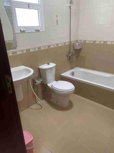 a bathroom with a toilet and a tub and a sink at Hostel Maral in Mawāliḩ