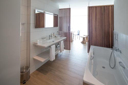a bathroom with a sink and a bath tub at Rössli Hurden in Hurden
