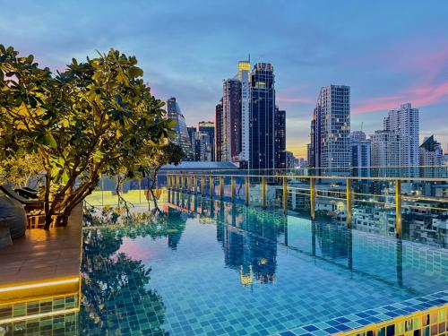a pool on the roof of a building with a city skyline at Civic Horizon Hotel & Residence in Bangkok