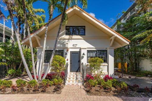 a white house with palm trees in front of it at Jefferson Avenue Suites in Miami Beach