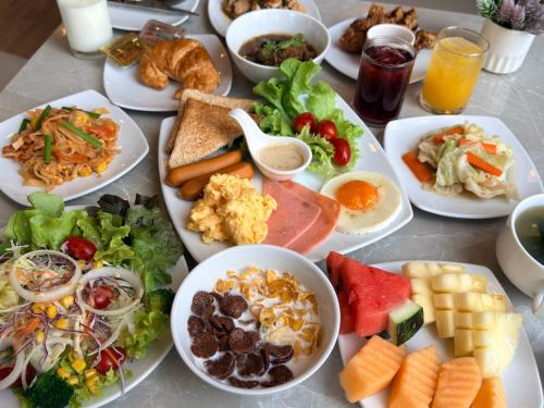 a table with many plates of food on it at Civic Horizon Hotel & Residence in Bangkok