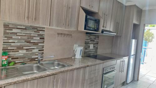a kitchen with a sink and a microwave at The Palace in Pretoria