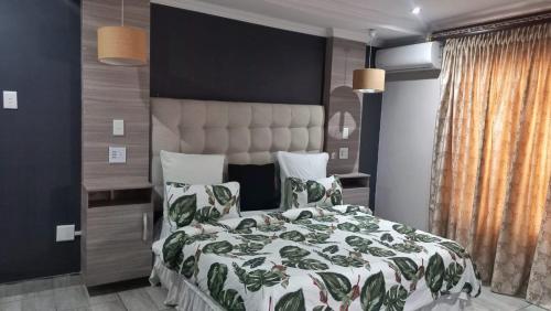a bedroom with a bed with a green and white comforter at The Palace in Pretoria