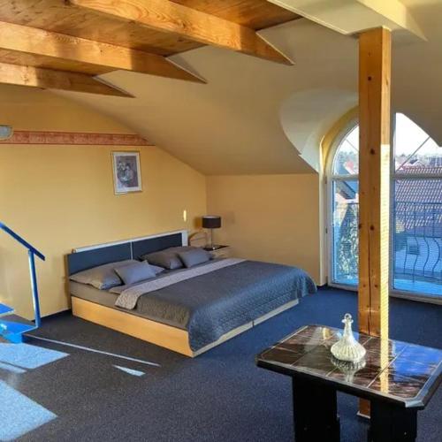 a bedroom with a large bed and a table at Penzion Ariane in Prague