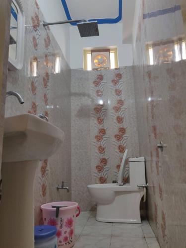 a bathroom with a toilet and a sink at Hotel Ratnouday in Kāndi