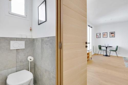 a bathroom with a toilet and a table with chairs at Charming studio for 2P - near Parc Monceau in Paris